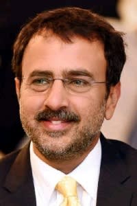 Smiling man in a suit and tie with glasses and a beard