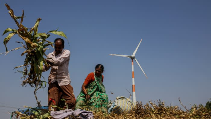 Workers in front of a turbine operating at a wind farm in Hubli, Karnataka