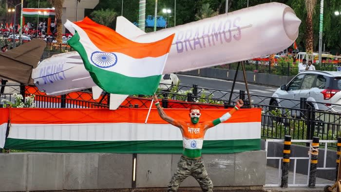 A man waves India’s flag in front of a replica of the BrahMos missile system in Ahmedabad in May