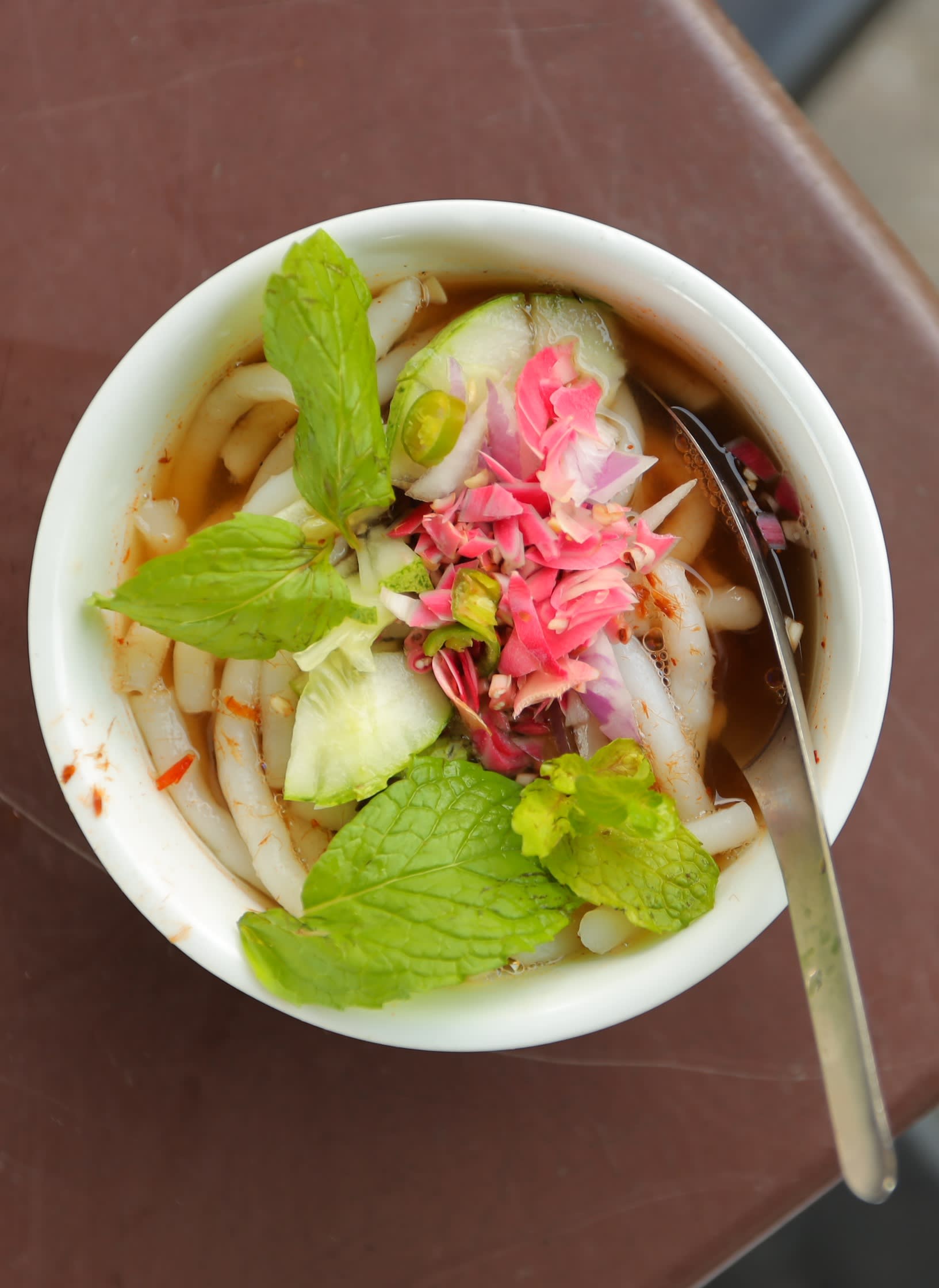 Penang Malay laksa: fish-based broth served with cucumber, torch red ginger lily flower, mint and onion