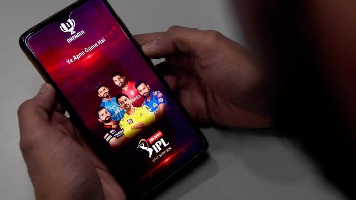 A person uses a Dream11 app on a smartphone
