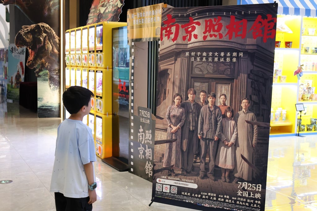 A boy looks at a poster of “Dead to Rights”, a film about the Nanking massacre, at a cinema in Beijing on August 4. Photo: Xinhua