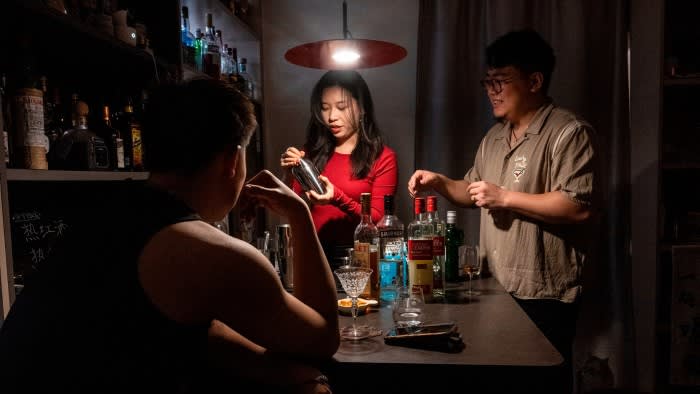 Yang, a homebar owner, watches a customer using a cocktail shaker