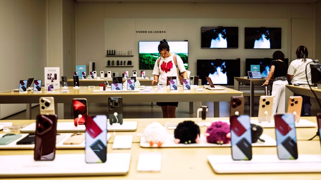 A customer looks at phones in a Huawei store in Shanghai, August 26 2025. Photo: EPA