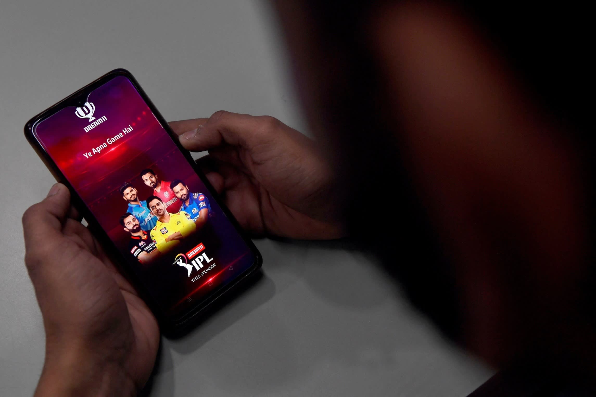 A user checks the Dream11 application of the Indian Premier League cricket tournament, on his mobile phone in New Delhi
