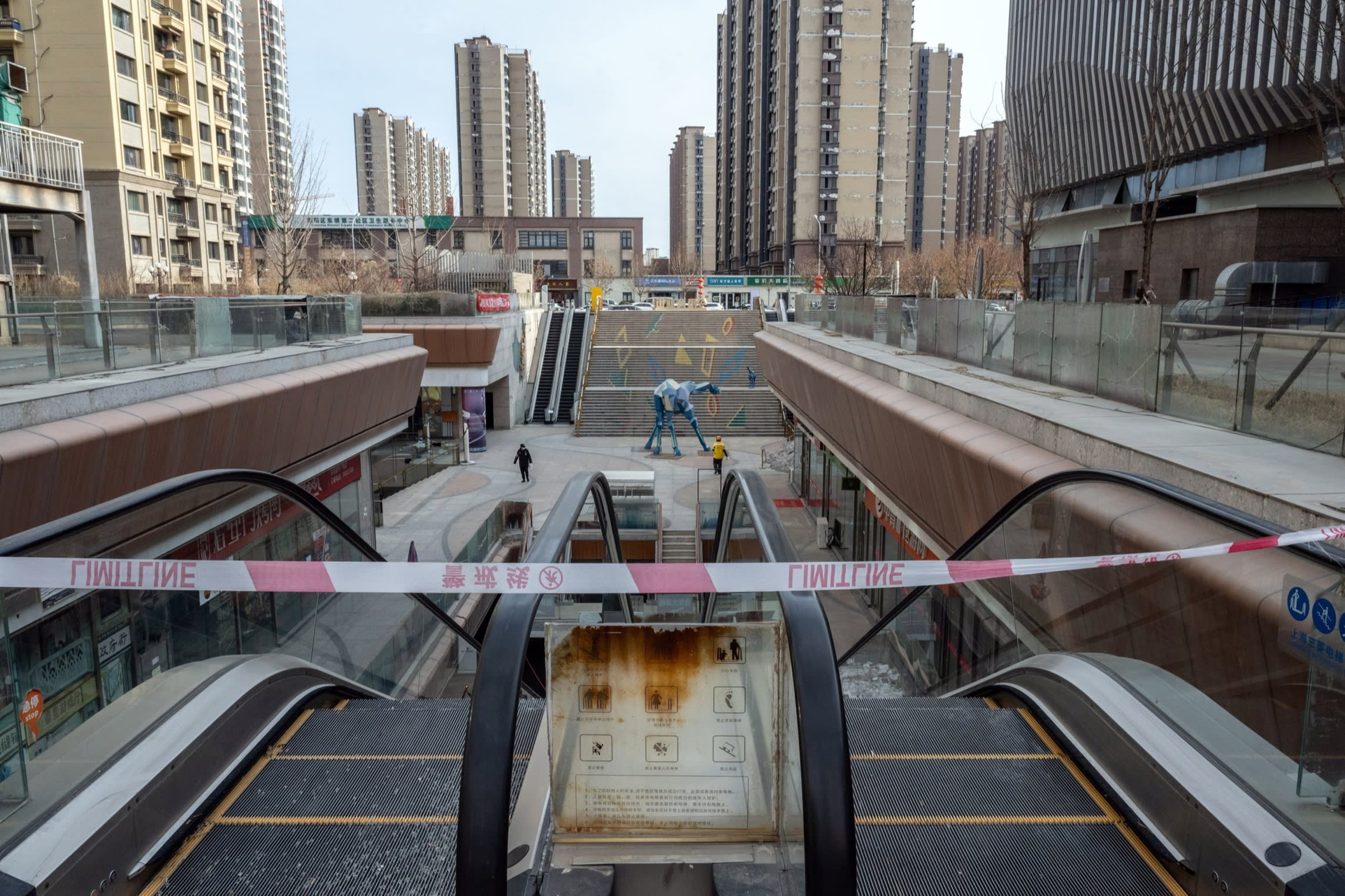 Barrier tape across escalators at the near deserted Evergrande City Plaza shopping mall