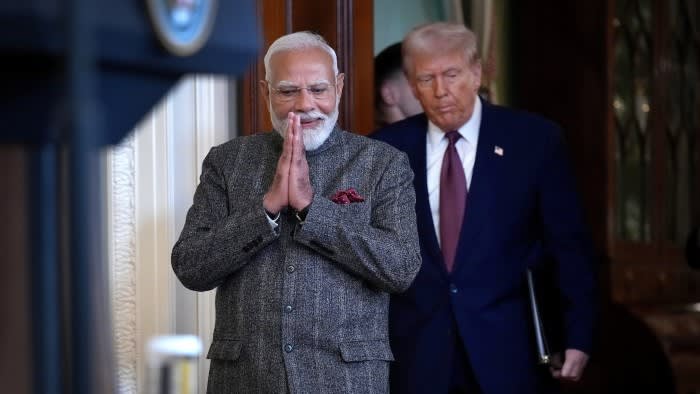 Modi making a greeting gesture with Trump behind him at the White House