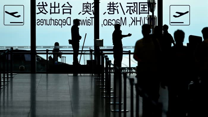 A security guard guides passengers at Beijing International airport