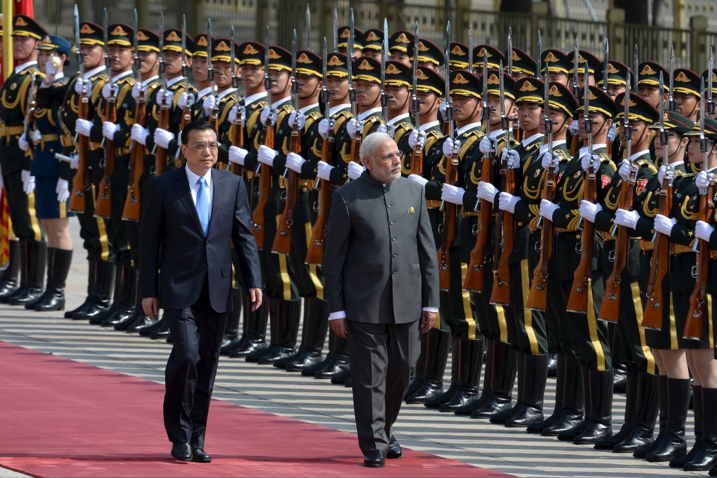 Narendra Modi and Li Keqiang on a red carpet in front of Chinese troops.