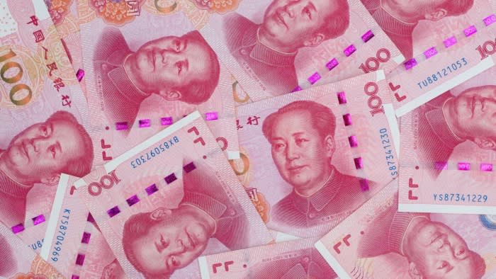 Several Chinese one-hundred renminbi banknotes are spread out and overlapping.