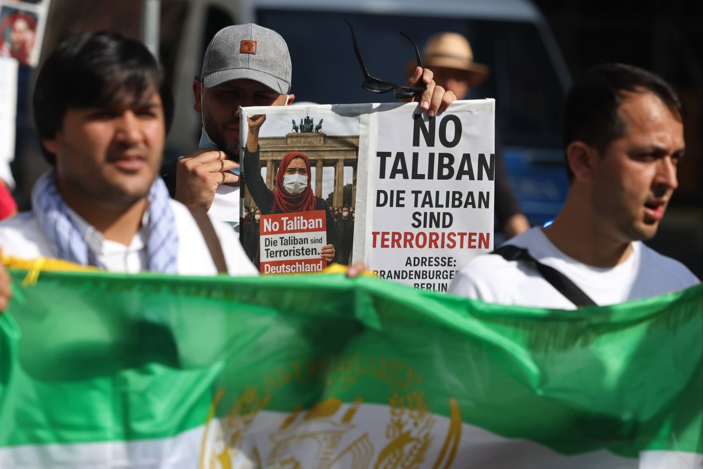 Protesters holding German-language placards describing the Taliban as terrorists