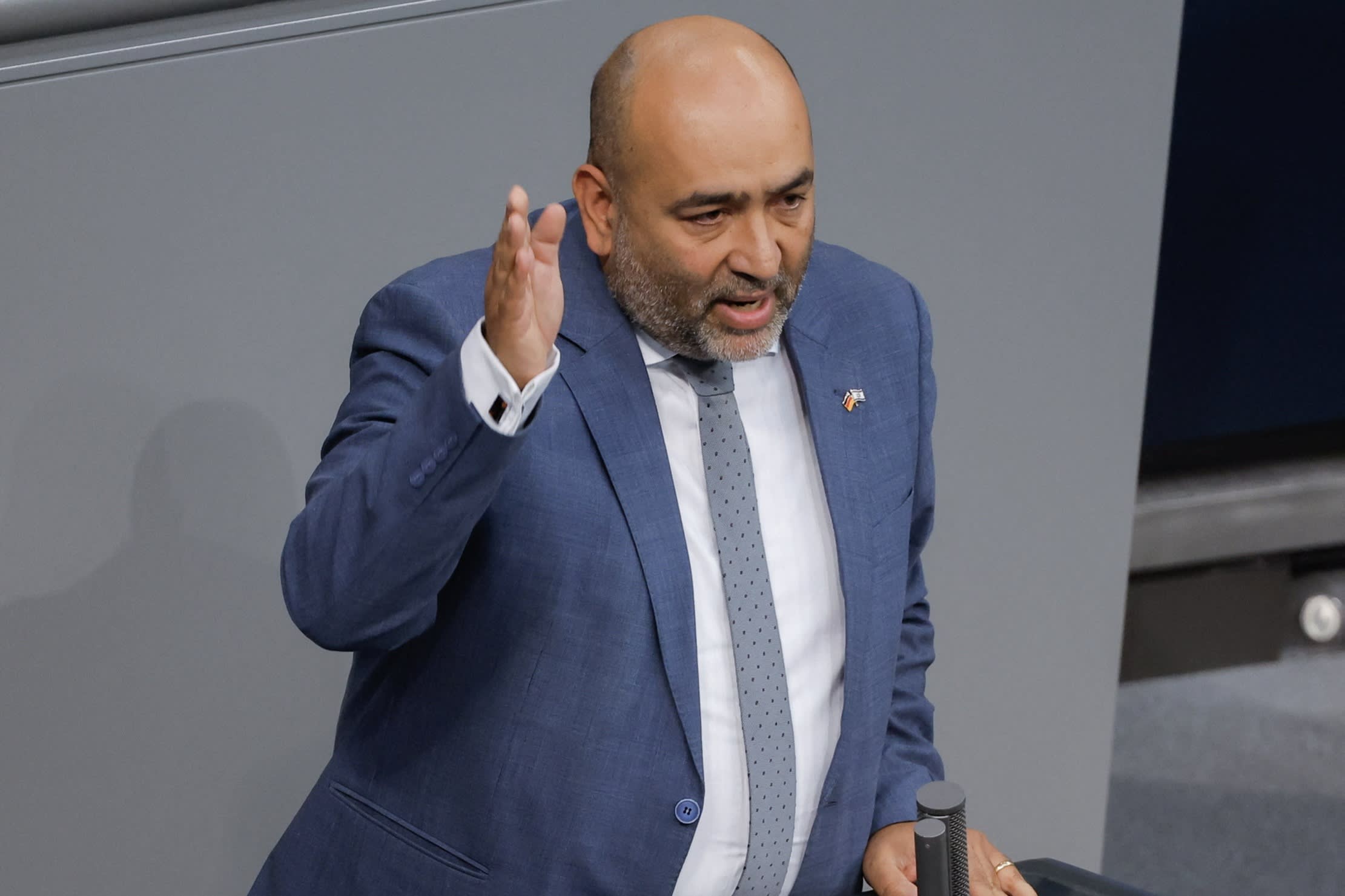 Nouripour raising his right hand as he speaks in the German parliament