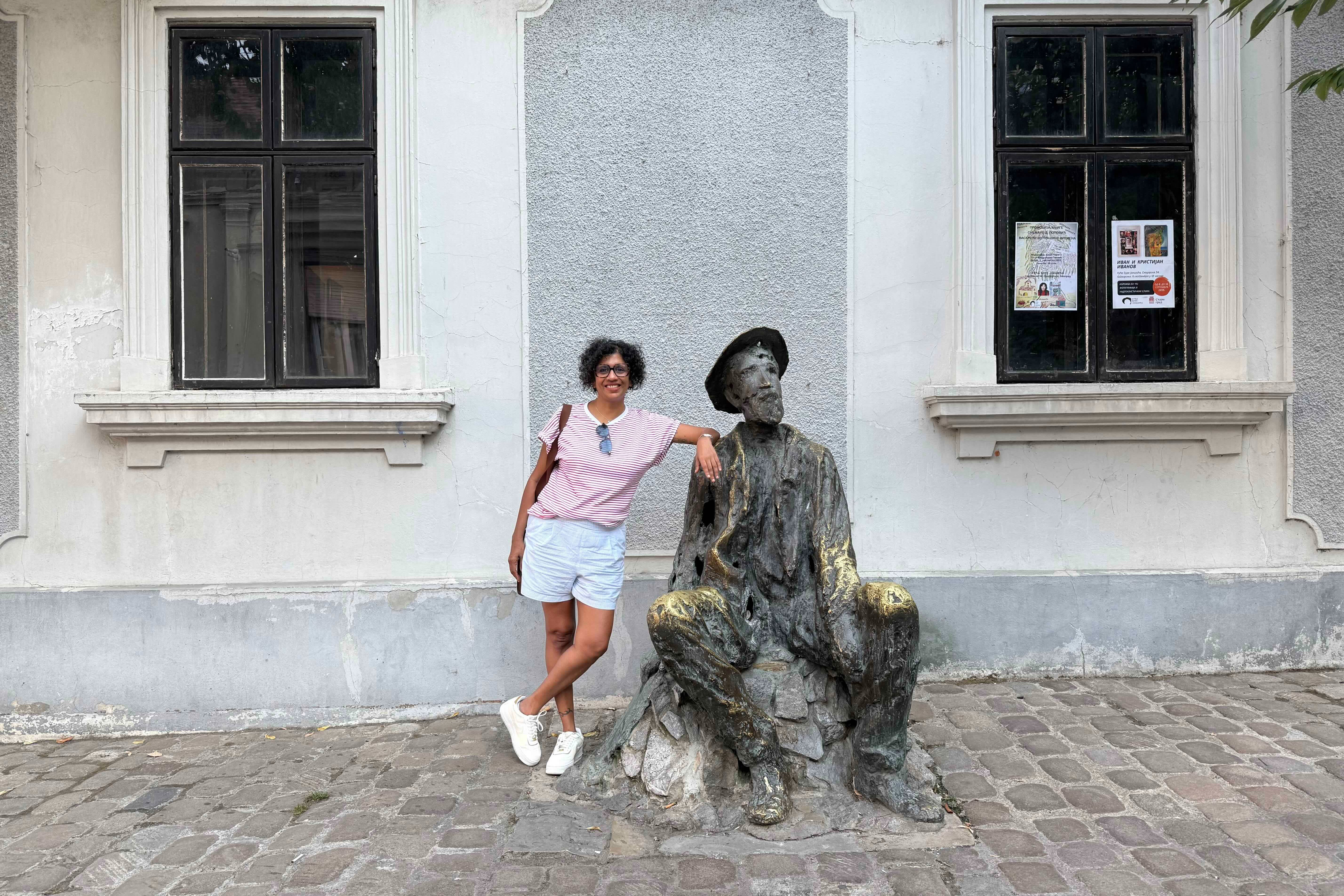 Veena Venugopal poses beside sculpture of Dura Jaksic in Belgrade, Serbia