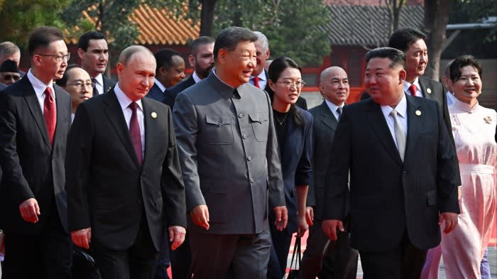 Vladimir Putin, Xi Jinping and Kim Jong Un walk together among other foreign delegates at a military parade in Beijing