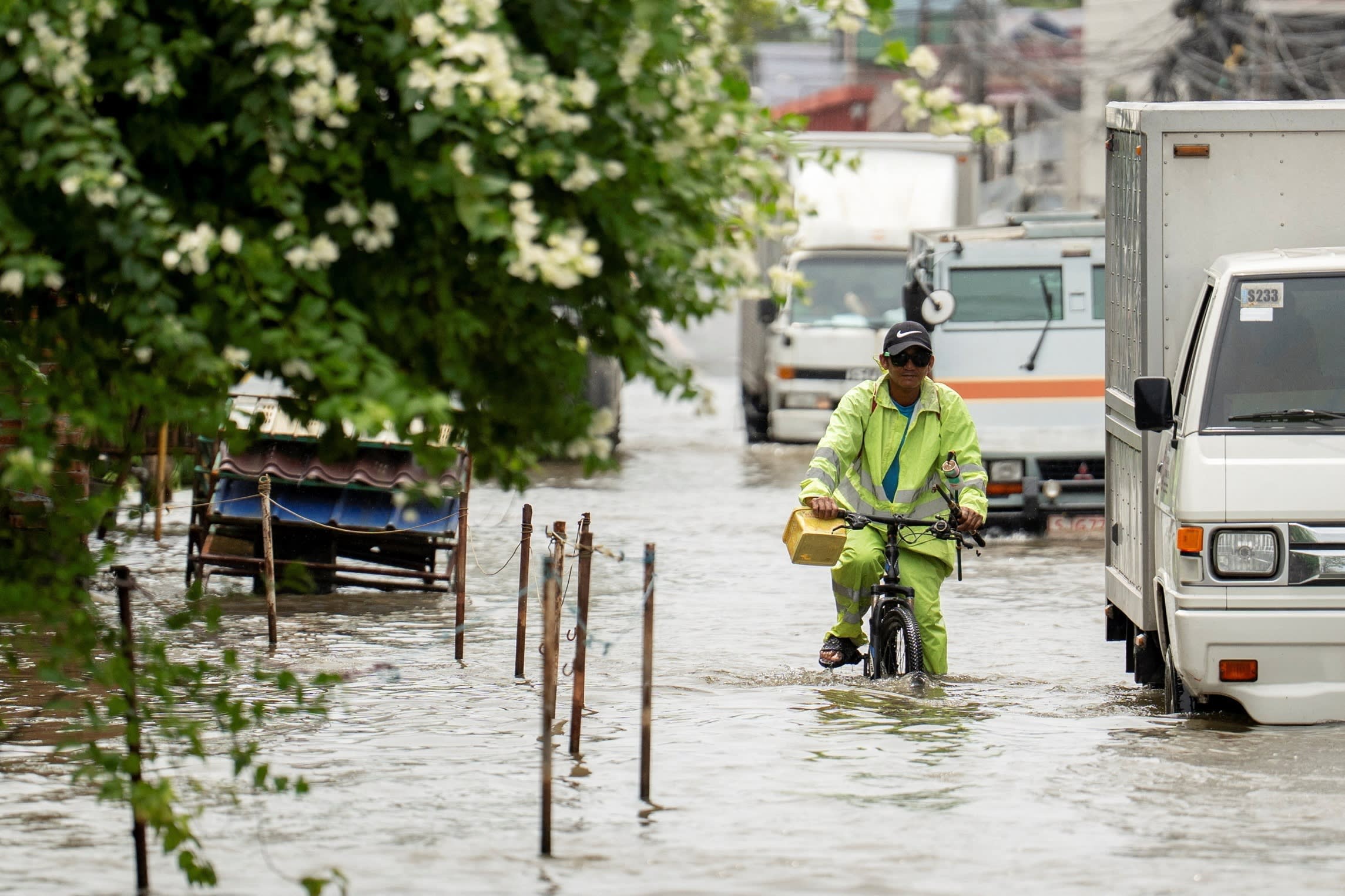 A man rides a bicycle through a heavily flooded street after Super Typhoon Ragasa in Apalit, Pampanga province, Philippines,