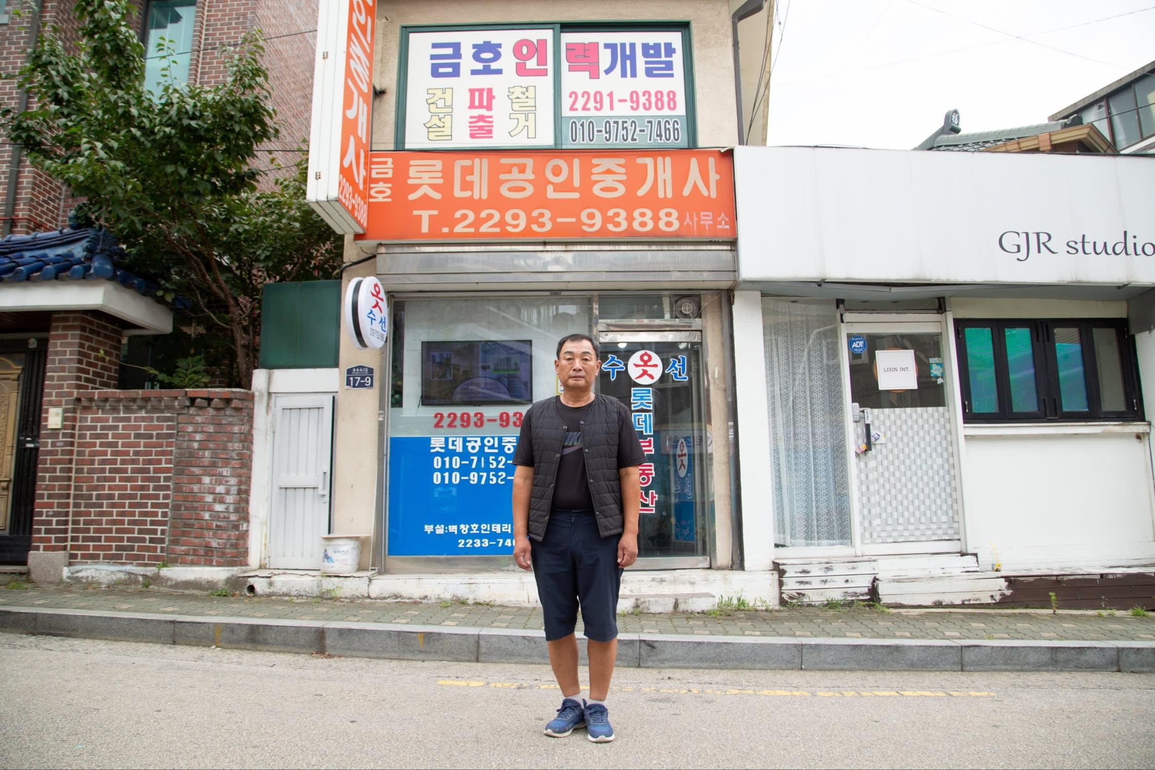 Shin Choong-ho stands outside his estate agency office in Seoul, South Korea