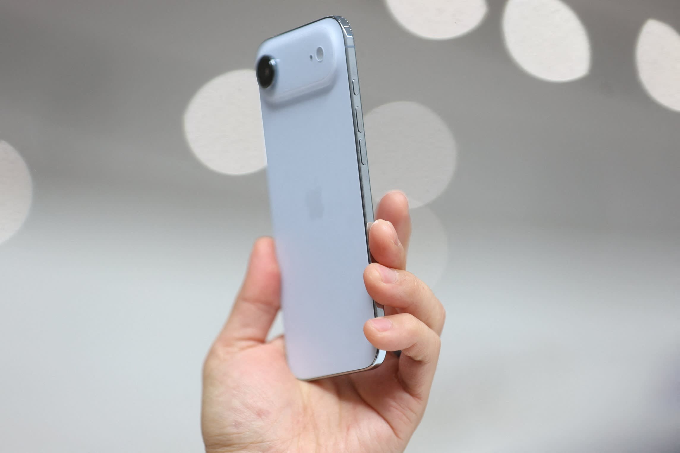 A person holds up a new iPhone Air, displaying its slim design and rear camera