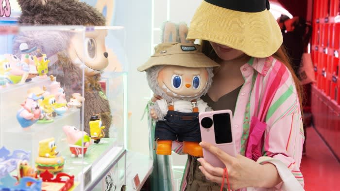 A woman holds a Labubu doll
