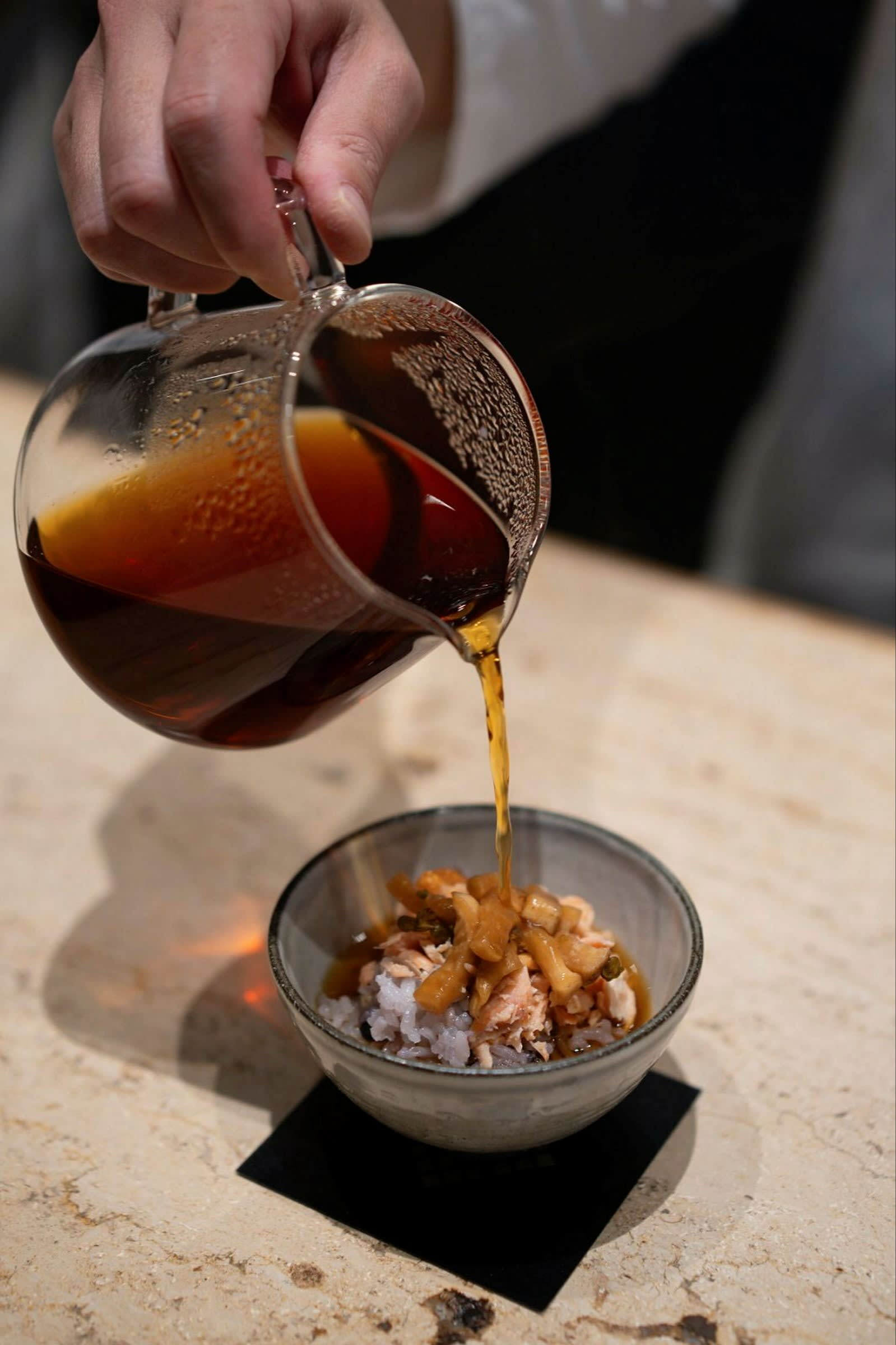 One of the courses in the coffee-based omakase at Tokyo’s Koffee Mameya Kakeru: cold brew infused with dried bonito flakes is poured over a small bowl of rice topped with salmon and pickled daikon.