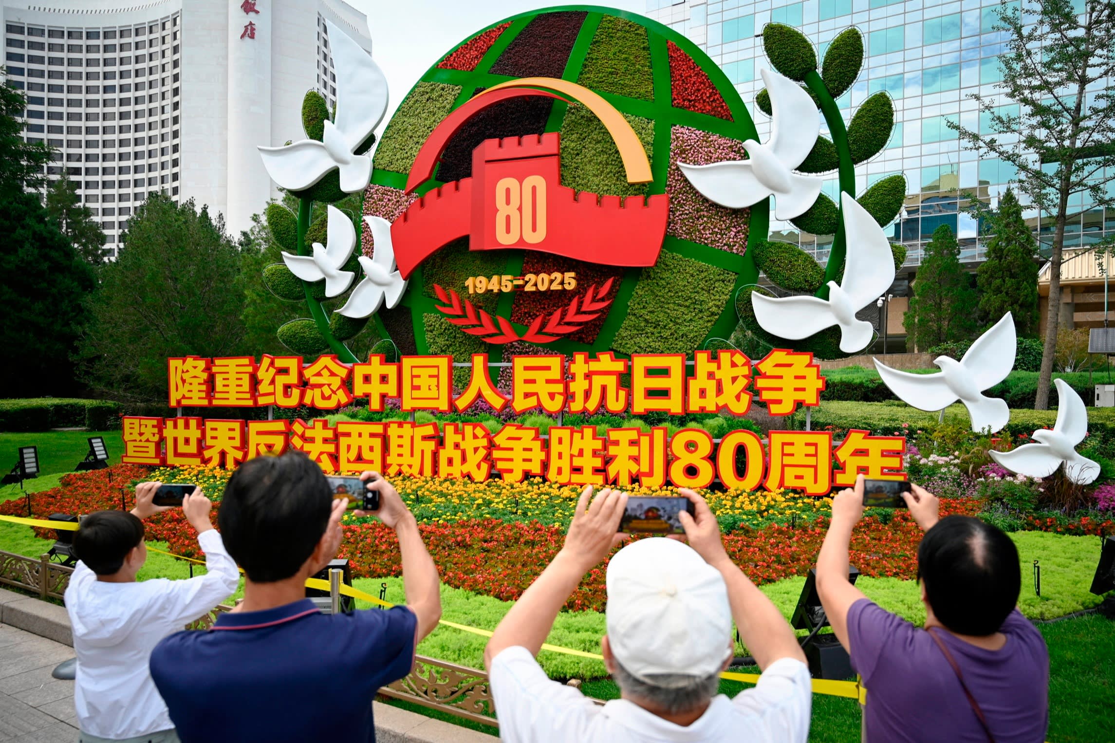 People take pictures of a flower installation commemorating the 80th anniversary of the victory over Japan and the end of the second world war in Beijing