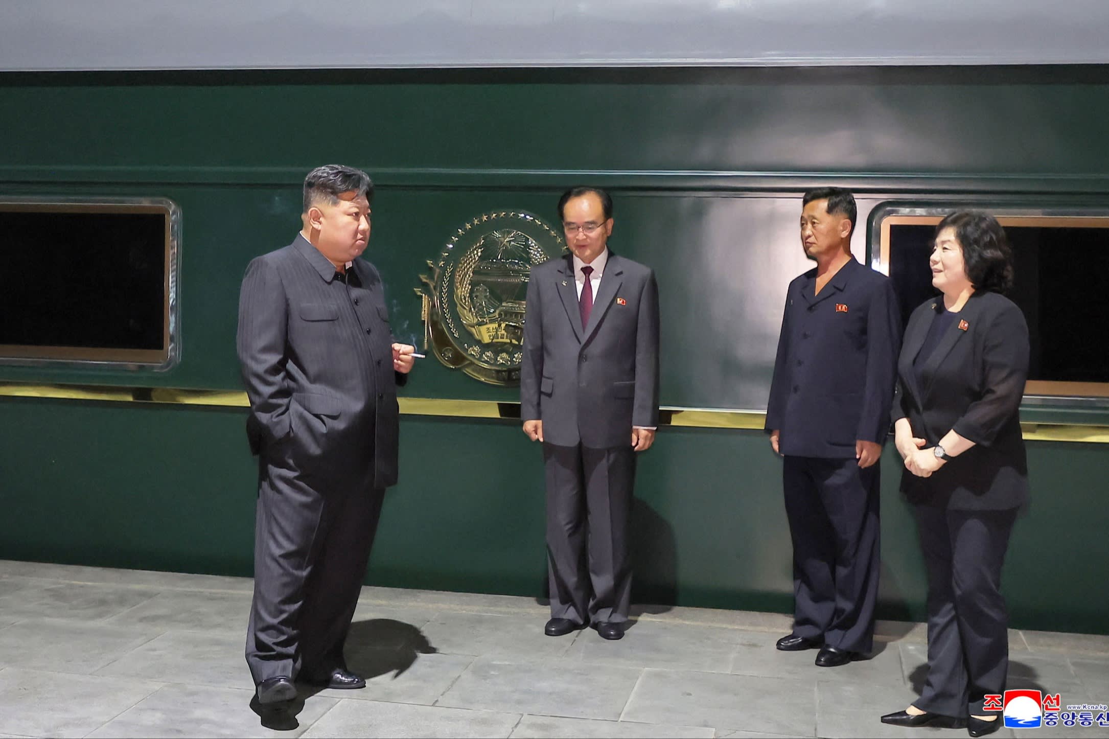 Kim smoking a cigarette on a platform outside his personal train