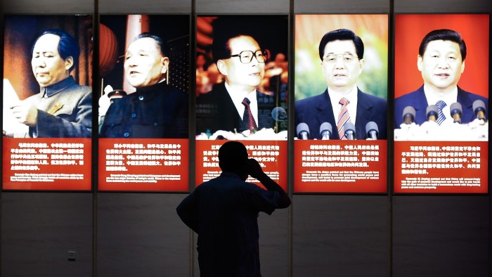 A visitor looks at portraits of former Chinese leaders Mao Zedong, Deng Xiaoping, Jiang Zemin, Hu Jintao and current President Xi Jinping at the Museum of the War of Chinese People’s Resistance Against Japanese Aggression in Beijing