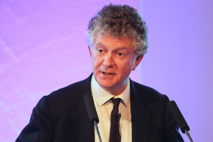 Jonathan Powell speaks at a podium.