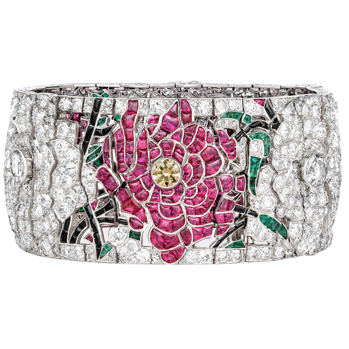 A wide bracelet with a floral design in rubies, emeralds and diamonds.