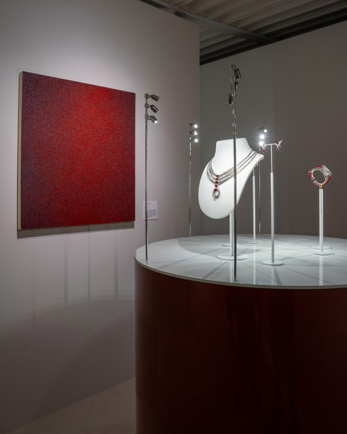 An exhibition display featuring jewellery under spotlights in a darkened gallery.