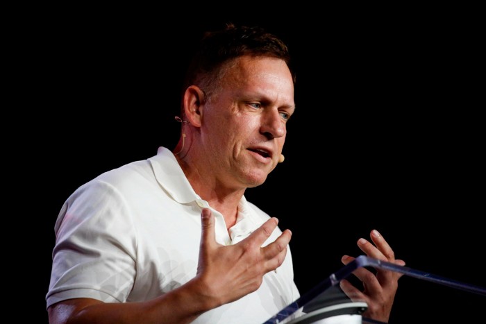 Peter Thiel gestures with both hands while speaking at a podium during the Bitcoin 2022 Conference.
