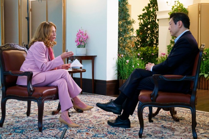 Lawrence Wong sits across from Roula Khalaf during an interview in an office with floral arrangements.