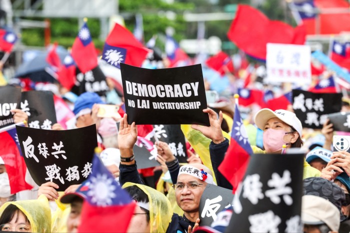 Protesters waving Taiwan flags and holding signs, one of which reads in English "DEMOCRACY, NO LAI DICTATORSHIP"