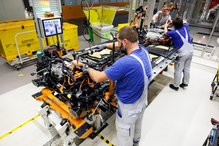 Workers assemble the drive unit and battery for a Volkswagen ID.3 electric car on a factory production line