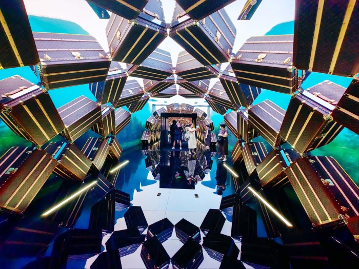 Visitors walk through a tunnel-like installation made of stacked Louis Vuitton trunks at the flagship store in Shanghai.