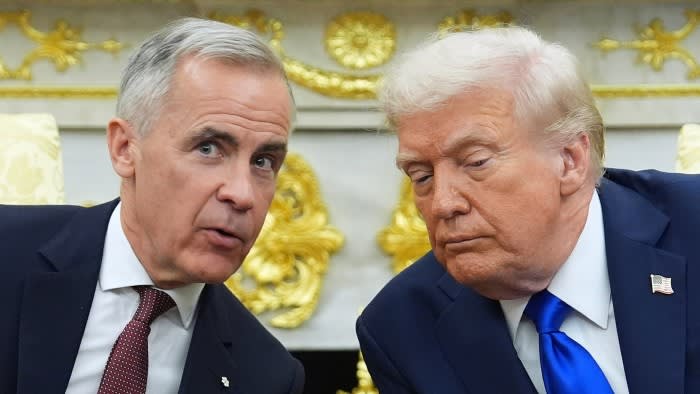 President Donald Trump and Canadian Prime Minister Mark Carney sit close together and speak in the Oval Office.