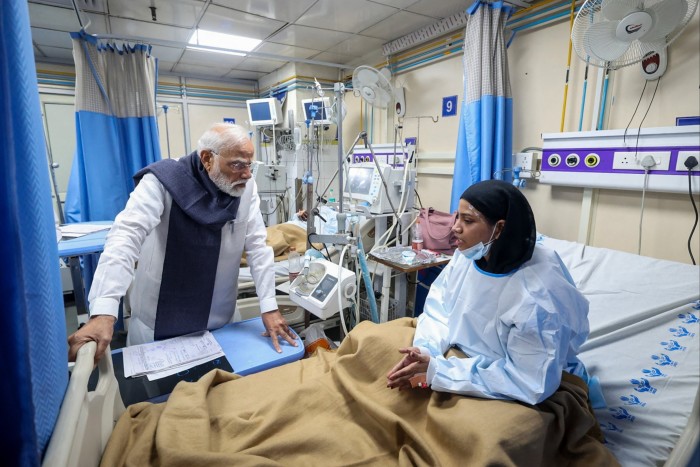 Narendra Modi speaks with an woman in a hospital bed at Lok Nayak Hospital.