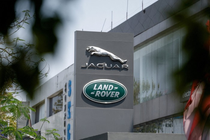 Jaguar and Land Rover logos on a sign outside a showroom building.
