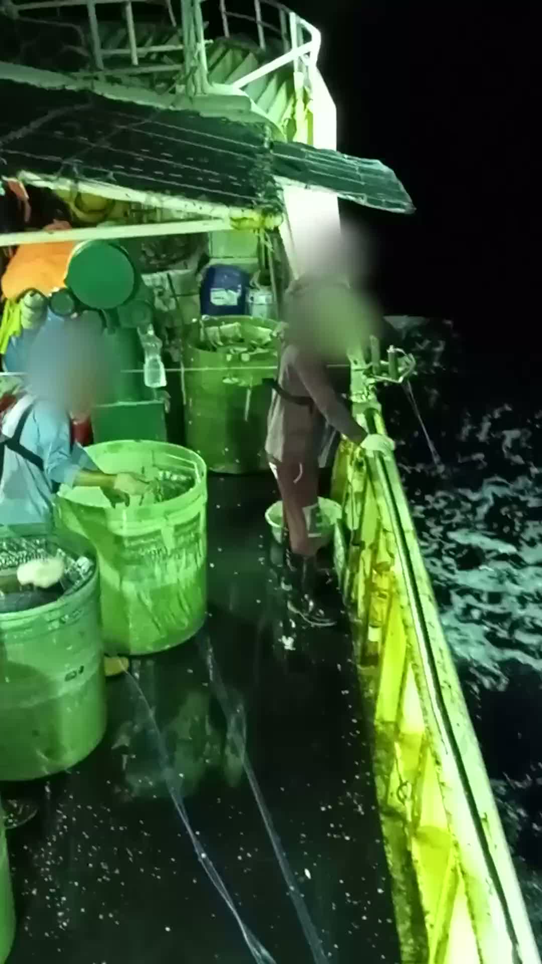 Alt text 1: Video footage shows crew in wet weather gear storing branch lines in drums on board a tuna fishing vessel