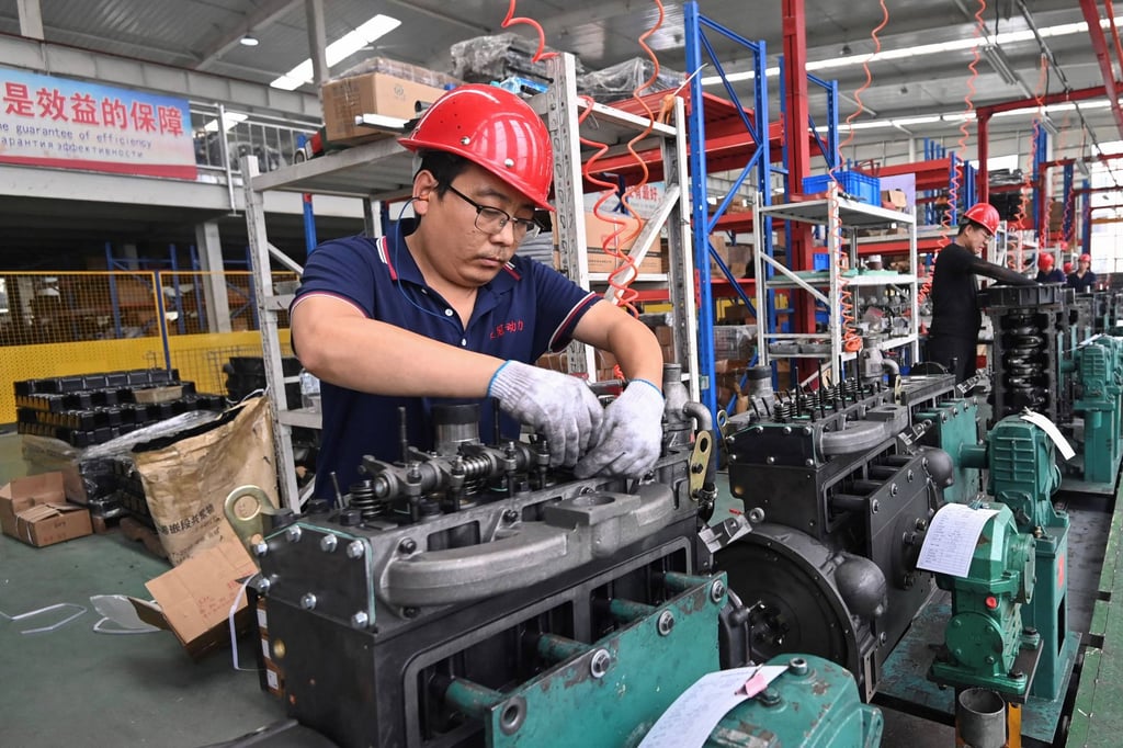 An employee works at a tractor and truck motor manufacturing company in Qingzhou, Shandong province, on August 27. Photo: STR / AFP