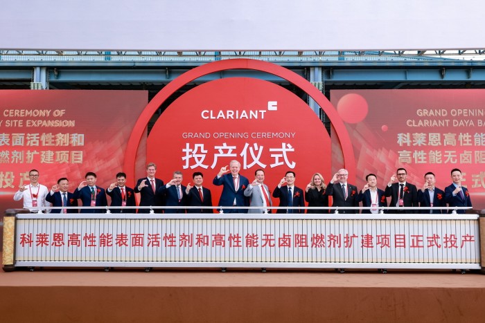 Executives and guests stand in a row on stage at the Clariant Daya Bay expansion opening ceremony, posing with celebratory gestures.
