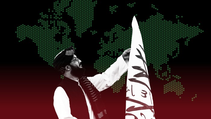 An Afghan man adjusts the Taliban flag before a press conference at the embassy of Afghanistan in New Delhi.