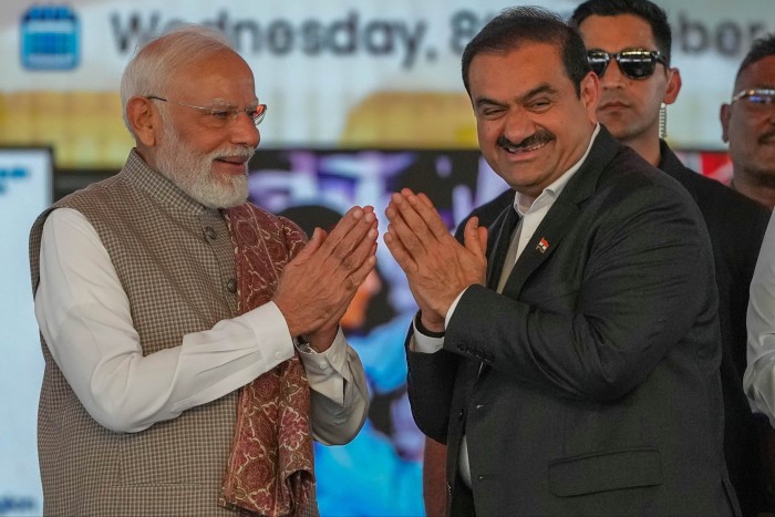 Indian Prime Minister Narendra Modi greets Adani Group chairman Gautam Adani at the Navi Mumbai airport