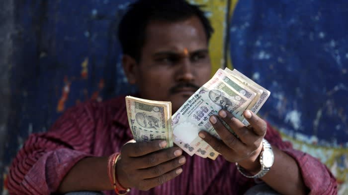 A vendor counts Indian currency notes in Mumbai