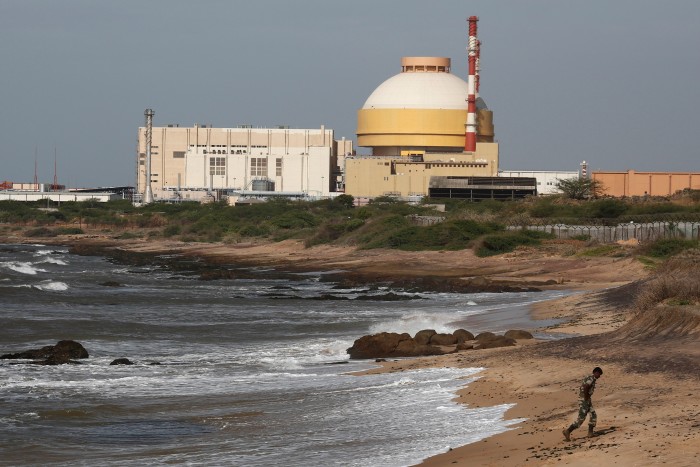 A policeman walks on a beach near Kudankulam nuclear power project in the southern Indian state of Tamil Nadu
