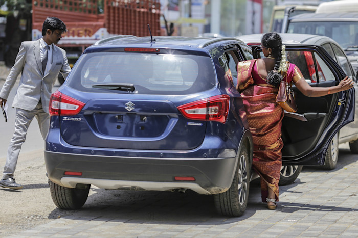 A customer climbs into a Maruti Suzuki S-Cross car for a test drive outside the company’s showroom in Chennai.