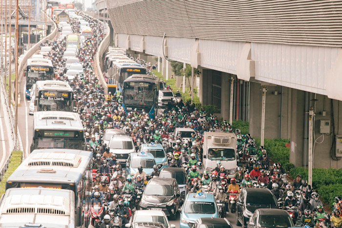 Heavy traffic jam with cars, buses, and a large number of motorcyclists crowding the road during Jakarta’s morning commute.