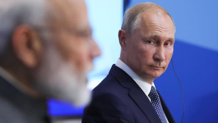Russian President Vladimir Putin listens to Indian Prime Minister Narendra Modi as he speaks to the media following talks at the Eastern Economic Forum in Vladivostok, Russia