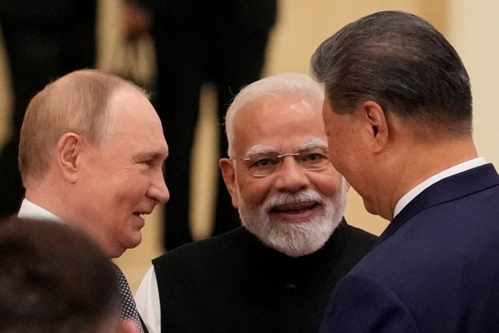 Indian Prime Minister Narendra Modi speaks with Russian President Vladimir Putin and Chinese President Xi Jinping in Tianjin, China in September
