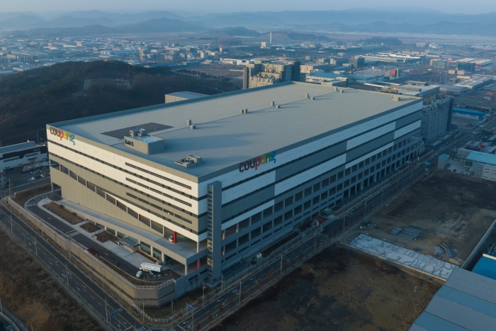 Aerial view of Coupang's large, multi-story fulfillment center building in Daegu, South Korea.