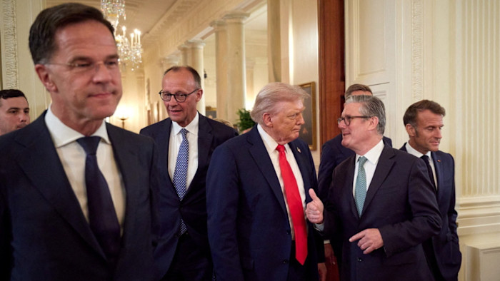 Donald Trump speaks with Keir Starmer as Mark Rutte, Friedrich Merz, and Emmanuel Macron walk nearby during a meeting at the White House.
